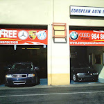 Storefront with two bay doors and a European Auto sign above banners for several European car brands
